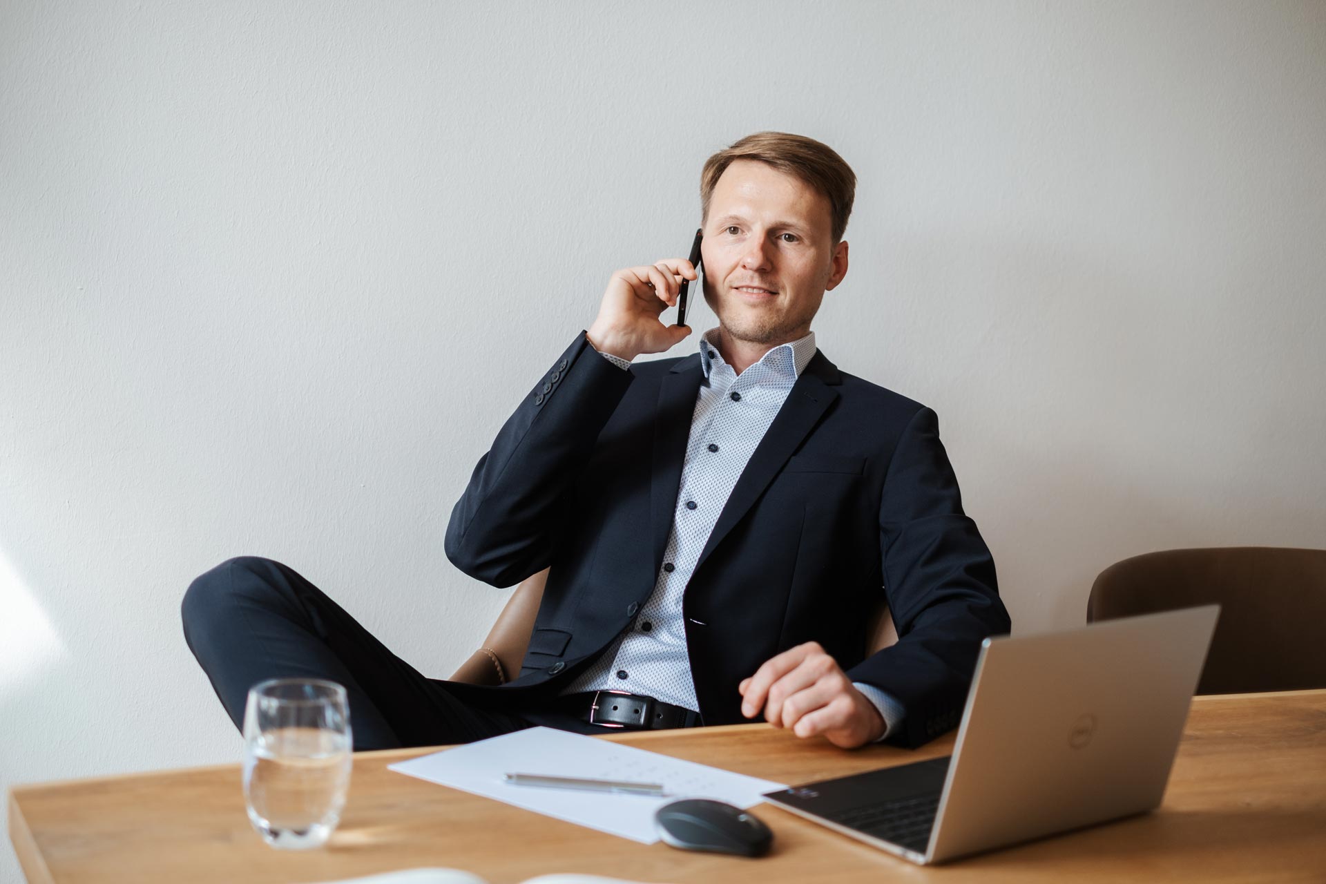 IT-Interim-Manager Dennis Quas sitzt auf einem Stuhl und telefoniert mit dem Mobile.