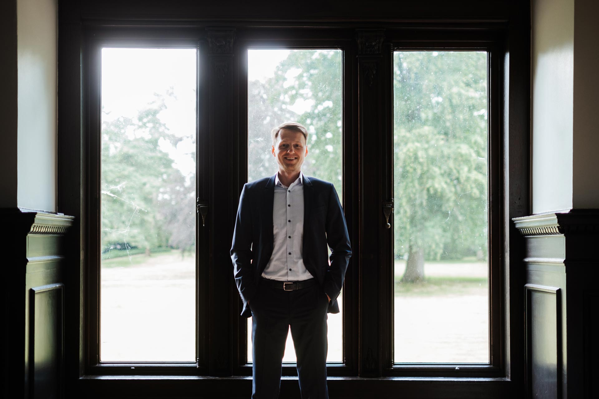 IT-Service-Manager Dennis Quas aus Bremen steht vor einem dreigeteilten Fenster.